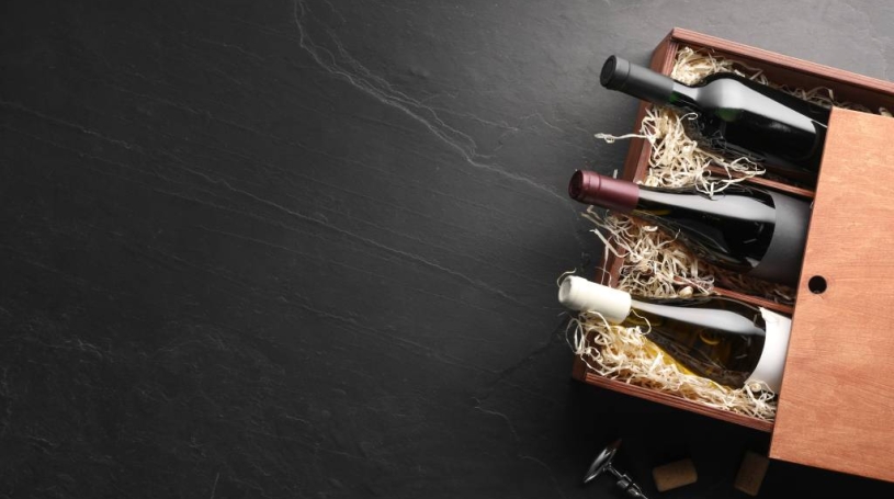 A wooden box with three bottles of wine